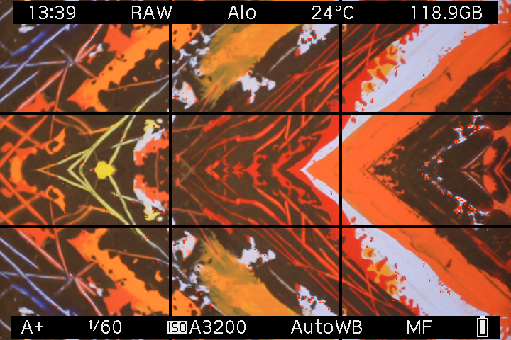 EOS M LiveView showing orange, yellow and black artwork with reflections around the center